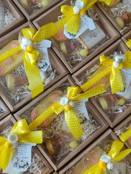 A budget-friendly baby shower gift set, including a wardrobe freshener, a teddy candle, and a goat milk soap.