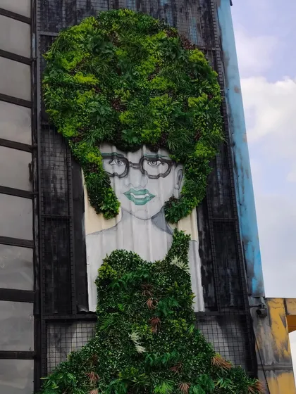 We go beyond simple green walls. This project at Bombay Adda shows our ability to create custom art murals, integrating greenery into a painted portrait to make a bold, unforgettable statement on a building's facade.
