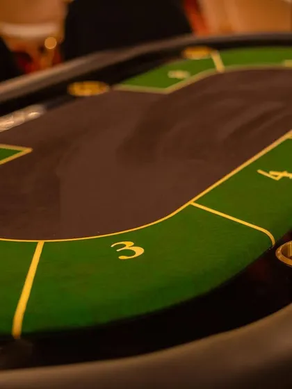 A detail shot of the professional-grade poker table, showing the custom felt and detailing that adds to the authentic experience.