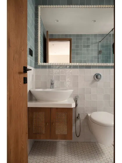 This view of the bathroom highlights the beautiful texture of the handmade-look tiles and the custom mirror frame. The space feels bright, fresh, and thoughtfully designed.