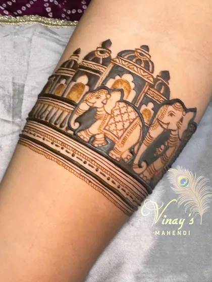 A beautiful arm band showcasing a procession of royal elephants in front of a palace facade. This design is perfect for adding a touch of grandeur to any look.