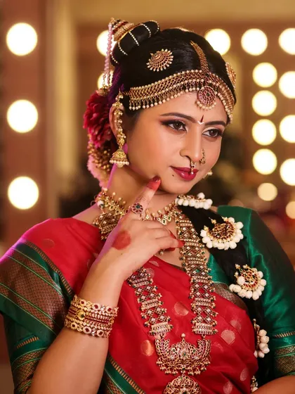 A classic portrait against a studio backdrop, focusing on the bride's elegant pose and the rich details of her attire.