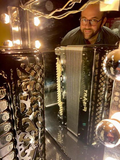 A behind-the-scenes look at our accordionist during the 'Little Italy' tour. This photo captures a moment of reflection in a dressing room mirror before a show.