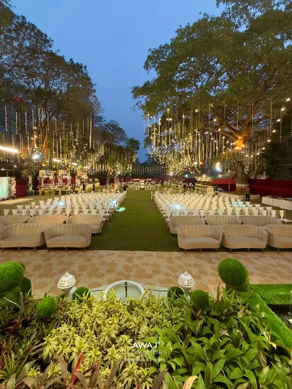 An enchanting outdoor evening setup, where strings of fairy lights hang like a canopy of stars over elegant guest seating, creating a truly magical and romantic atmosphere for your celebration.