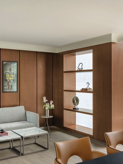 A lounge area within a director's suite at 'The Layered Office'. The space is designed for informal meetings or relaxation, with comfortable seating and views of the outdoor terrace.