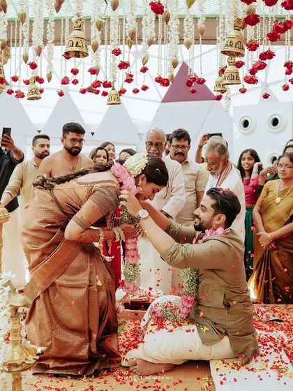 The groom ties the thali around the bride's neck, a pivotal and sacred moment of their union.