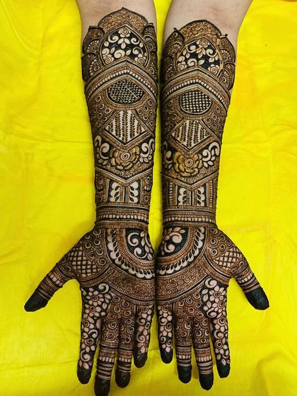 This design showcases a beautiful flow from the detailed floral work on the fingers to the bolder, more structured patterns on the forearms.