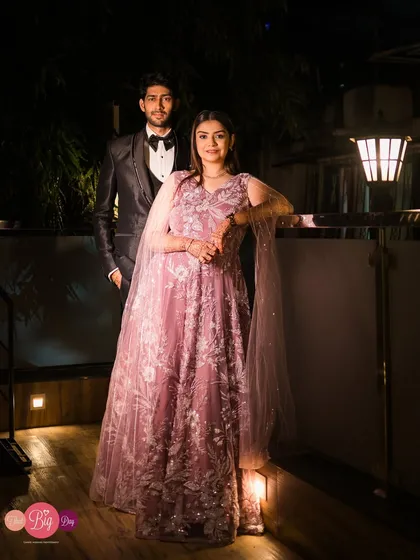 A full-length portrait showcasing the couple's elegant evening wear. The warm lighting creates a sophisticated and romantic ambiance.