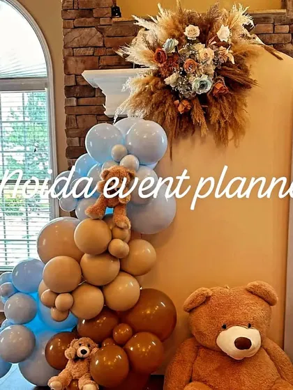A cozy corner setup for a baby shower, combining brown and blue balloons with dried floral arrangements for a warm, rustic feel.