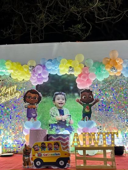 A dazzling Cocomelon stage with a shimmer wall backdrop. The pastel balloons and character cutouts create a festive and fun photo area.