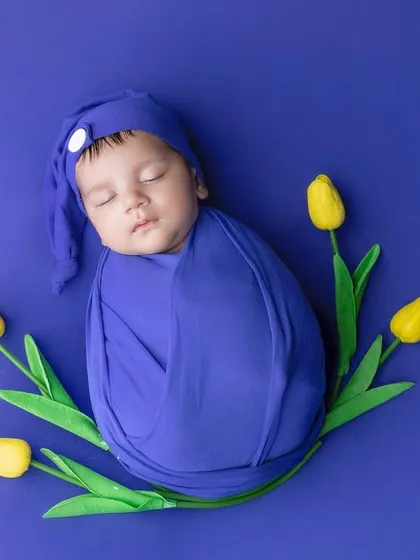 Simple and striking, the bold blue background makes this swaddled baby pop.