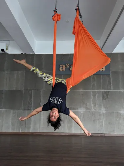 High on life and the joy of movement. A student hangs upside down with a huge smile, capturing the fun and playful spirit of our aerial classes.