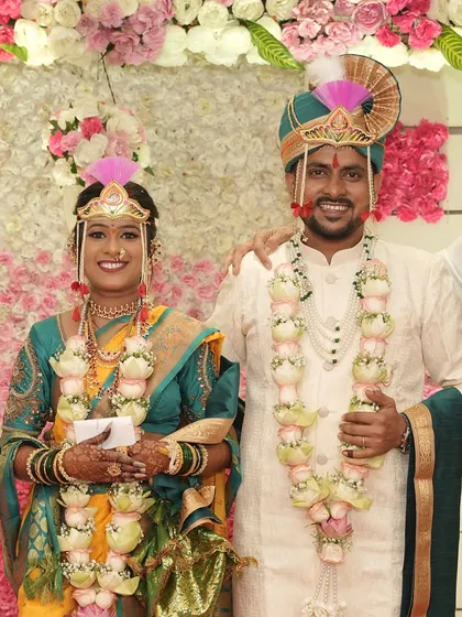 The happy couple posing for a photo. I work to create a bridal look that photographs beautifully, capturing the joy and tradition of your Maharashtrian wedding.