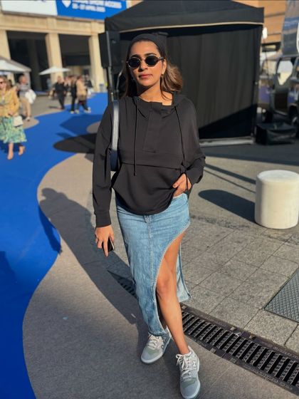 A casual but edgy look. I love this asymmetrical denim skirt paired with a simple black hoodie and sneakers for a cool, off-duty vibe.
