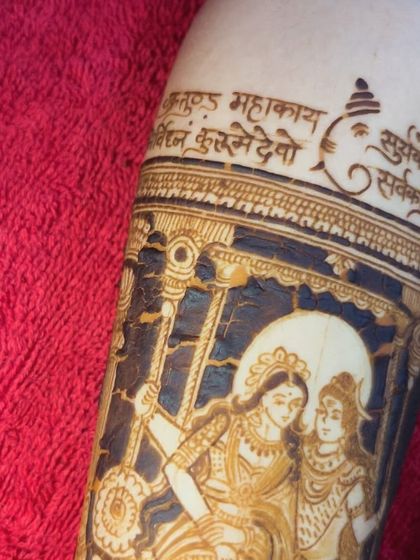A close-up of a Shiv Parvati portrait, with a Ganesh mantra written in Sanskrit above it.