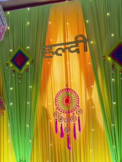 A bright and cheerful Haldi backdrop with lime green and yellow drapes. The setup is decorated with fairy lights, dreamcatchers, and colorful hangings for a fun and modern vibe.
