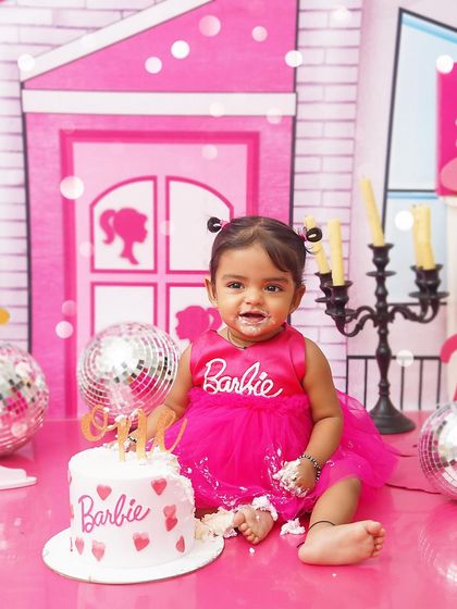 A Barbie-themed cake smash for a little fashionista. After playing in her dream house, it's time for a sweet treat, complete with a pink Barbie cake and disco balls.