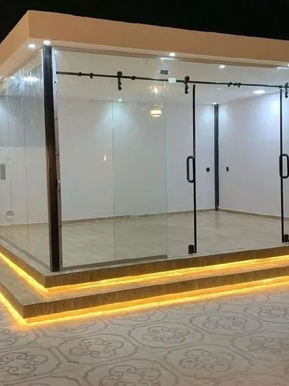 A unique glass cabin design featuring exterior sliding glass doors on a barn-style track system. This structure is elevated on a platform with integrated step lighting, showcasing our ability to incorporate custom features and modern aesthetics into our prefab rooms.