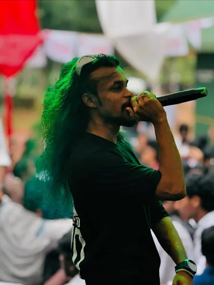 A close-up shot during a performance at a college festival. My look, especially my long hair, is a big part of my 'Mudiyan DJ' identity on stage.