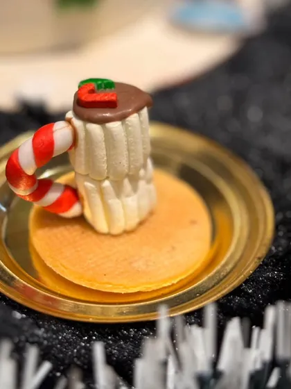 A mini hot chocolate mug dessert, one of our exclusive Christmas goodies. This tiny treat is crafted to look like a cozy mug of cocoa, complete with a candy cane handle.