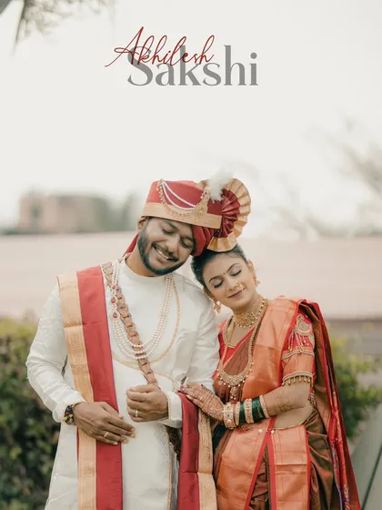 A sweet and candid portrait of a Maharashtrian couple. The bride rests her head on the groom's shoulder, both sharing a happy, relaxed moment.