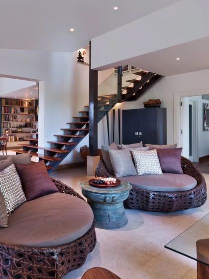 In the living-cum-dining room of Aishbagh, we used texture and sculptural forms to create interest. The large woven daybeds offer a comfortable and unconventional seating option, perfect for lounging and enjoying the view.