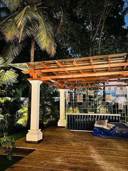 This outdoor seating area demonstrates our expertise in hardscaping and lighting. The custom-built wooden pergola provides structure and a place for evening lights, turning the garden into a usable and ambient space after sunset.