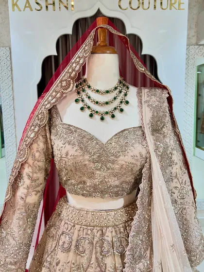 A close-up of a bridal blouse with a sweetheart neckline and heavy silver embroidery, paired with a stunning emerald necklace. This shows how I can help style your whole look.
