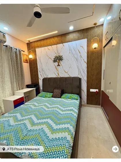 A warm and inviting bedroom design combining a marble-finish accent wall with vertical wooden fluting. The wall-mounted tree artifact adds a unique, artistic element.