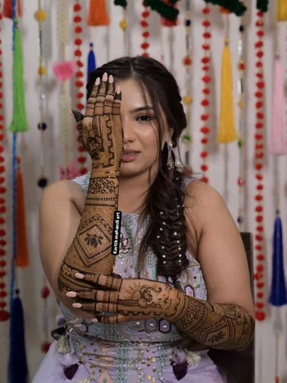 A beautiful pose highlighting a full-arm bridal design. The pattern features bold lotus motifs, a popular and auspicious choice for brides.