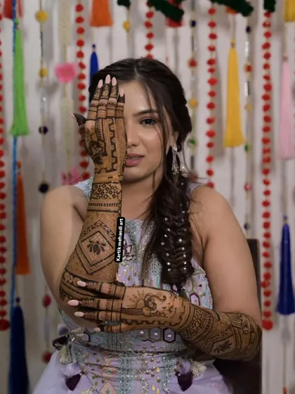 A beautiful pose highlighting a full-arm bridal design. The pattern features bold lotus motifs, a popular and auspicious choice for brides.
