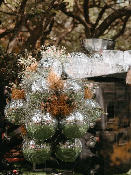 A fun and modern bar detail, with a cascade of disco balls and dried flowers.