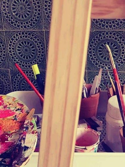 A peek at my art station with a colorful palette, brushes, and an easel. This is where the creative magic begins.