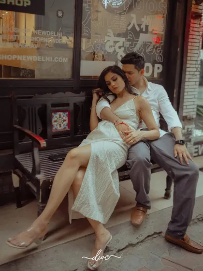 A stylish, urban pre-wedding shoot, with the couple sharing an intimate moment on a bench in the charming streets of a city market.