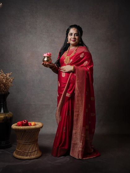 This full-length portrait showcases the elegance of traditional attire for a maternity shoot. The studio setup is kept minimal to let the mother-to-be and her beautiful saree shine.