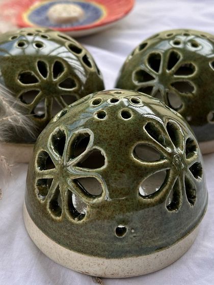 A slightly different angle of the green dhoop holders, showing the small holes on top for the incense smoke to escape.