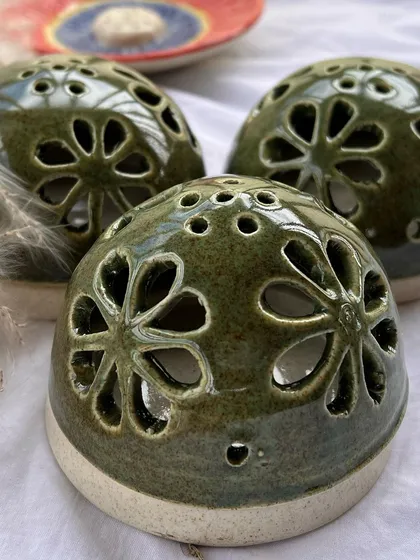 A slightly different angle of the green dhoop holders, showing the small holes on top for the incense smoke to escape.