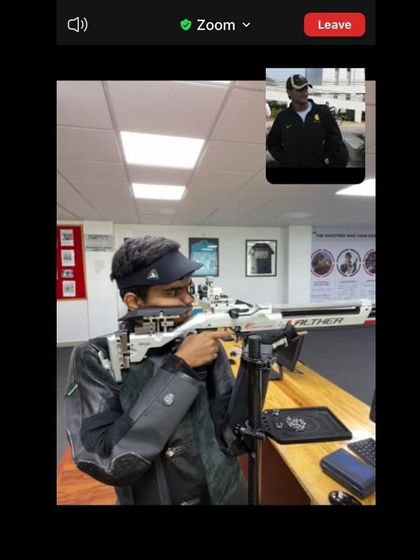 A close-up of a shooter receiving live instruction during an online session, showcasing how we use technology to maintain a high standard of coaching.