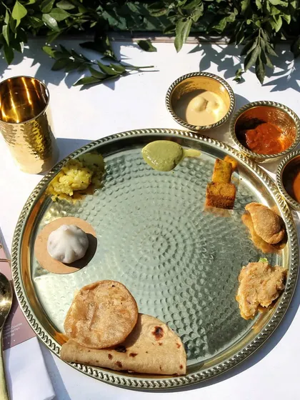A beautifully arranged plate for a Pangat, showcasing a variety of Maharashtrian delicacies. Each item is carefully placed to create a balanced and visually appealing meal for the guests.