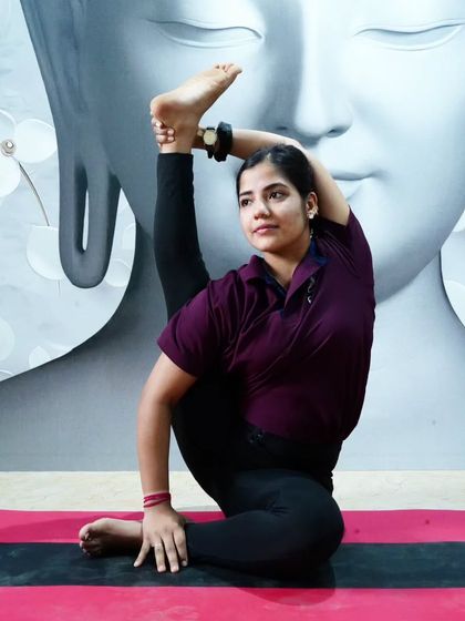A student holds a standing compass pose, a beautiful expression of hamstring and hip flexibility.