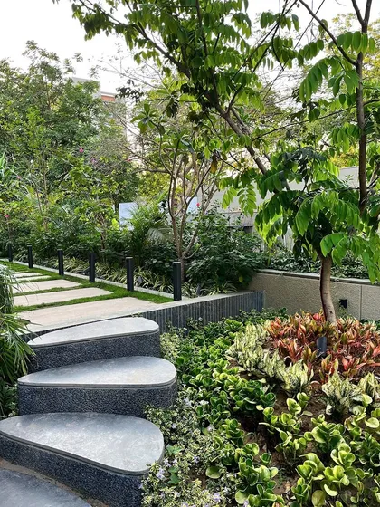 A stepped pathway ascends through a densely planted garden bed. I use changes in elevation and curved steps to make the journey through a garden more engaging and to reveal views slowly.