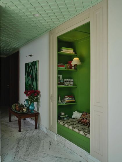Tucked into the heart of the home, this reading nook is a front-row seat to the theatre of daily life. The leafy green alcove, filled with books and floral cushions, is a place to linger between rooms and thoughts.