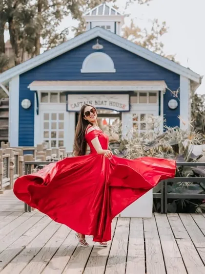 The full skirt of our red satin gown is perfect for twirling shots. It creates beautiful movement and a sense of joy in your pre-wedding photos.