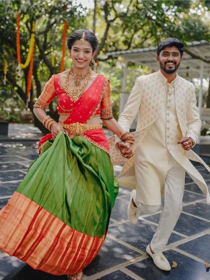A joyful couple runs hand-in-hand through the venue courtyard. This candid shot is full of energy and happiness, perfectly capturing the spirit of their engagement day.
