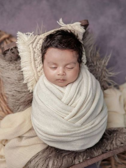 A bundle of peace. This overhead shot of a swaddled baby is a classic portrait, made special with the use of soft, neutral tones.