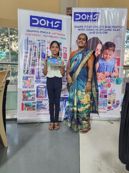 A participant and her guardian pose with her completed artwork. Our workshops are for everyone, and it is wonderful to see family members of all generations supporting our young artists.