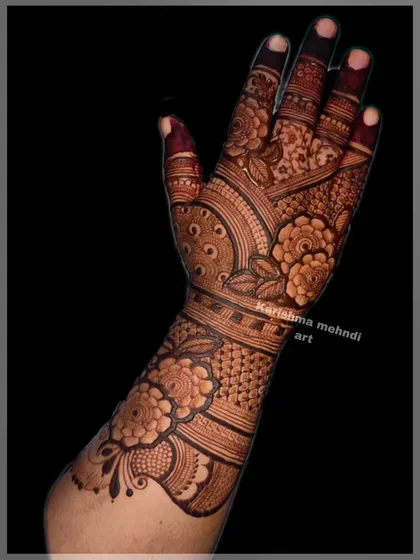 The front view of the same intricate design, showing how the pattern continues onto the palm. The combination of floral motifs and dense jaali work creates a classic and beautiful bridal look.