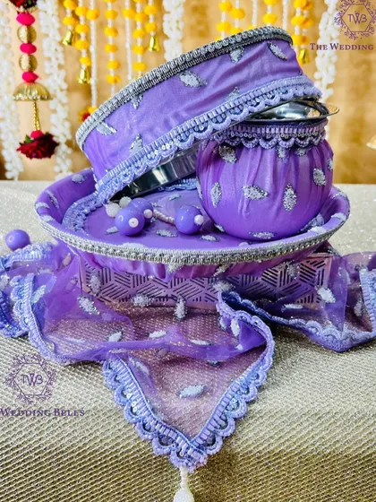 A stunning lavender Karwachauth thali set. The rich color and delicate silver embroidery make it a luxurious choice for the festival.