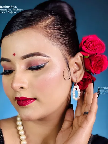 Learn to recreate timeless beauty with this retro look, featuring a sharp winged eyeliner, bold red lips, and a classic hair bun with roses.