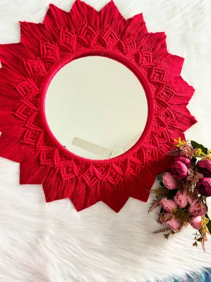 This shot shows the scale of the red mirror mandala next to some flowers. It's a bold and beautiful piece of handmade art.